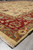 Low angle across ivory field into layered red and camel borders with floral vinework
