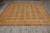 8' x 10' Chobi Peshawar wool rug laid flat on grey tile showroom floor