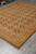Angled floor view showing soft olive green panels and wide camel palmette border