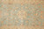 Close-up of ivory 8 petal rosette and rust vine scrolls on sage green wool field
