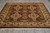 Angled showroom view of traditional Oriental area rug with ivory border and cream fringe ends