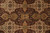 Detail of mirrored paisley boteh motifs and ivory star medallions across the burgundy field