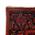 Corner close up showing ivory fringe, navy main border and salmon rosette motifs in wool