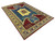 Angled floor shot showing oversize Kazak wool rug with latch hook medallions and multiple geometric borders
