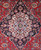Close up of the ivory and navy Kashan medallion core with pale blue rosette and curling leaves