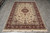 6'1" x 9'2" Sino-Tabriz rug photographed on grey plank flooring showing full ivory floral field