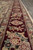 Burgundy border detail with cream guard stripes, palmettes and multicolored flowers along the edge