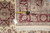 Tape measure and hand woven Oriental rug hang tag placed beside the burgundy border