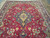 Cherry red field of a hand-knotted Tabriz rug with stepped navy medallion and ivory center