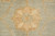 Close-up of a gold rosette woven against pale seafoam wool pile with vegetable dyed tones