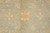 Detail of gold vine scrolls and star flowers spread across the soft green wool ground