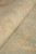Rolled edge of the 8'10" x 11'2" rug showing plush low natural wool pile