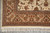 Corner of the 5'8" x 8'9" rug with brown cartouches, tan border and cotton fringe