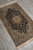 Diagonal view of hand-knotted wool and silk pile showing arabesque vinework across the midnight blue ground