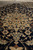 Pile detail showing silky sheen, palmettes and curling leaves worked in cream against deep navy wool
