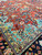 Turquoise corner spandrel meeting the ivory vine guard stripe on this vintage Sarouk wool rug