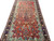Angled floor view showing all-over floral field, turquoise spandrels and deep navy main border