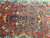 Close view of the central floral cluster, soft abrash and small navy palmettes on coral