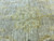 Macro of hand-knotted rows with mustard gold rosettes on beige ground, showing pile texture