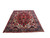 Angled floor view showing navy border and cream corner brackets on this hand-knotted wool Tabriz rug