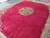 Angled view of the borderless Kerman rug with light sheen running across the crimson wool pile