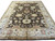 Ivory main border and dark brown field seen from the foot of this large wool rug