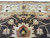 Detail of ivory border rosette cartouche meeting the brown field with peach palmette below