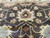Hand-knotted wool pile close-up showing rust palmette, ivory vine scroll and serrated leaves