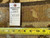 Back tag reading rug number 6402 size 9.3 x 12.2 beside tape measure on weave