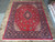 9'10" x 13' Persian Sarouk rug laid flat on stone floor showing full floral field