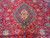 Detail of the blue lobed medallion with ivory floral center on a tomato red ground