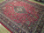 Angled view showing the all over floral field, ivory guard borders and deep indigo main border