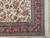 Corner detail with red floral border, olive guard stripes and hand-tied ivory cotton fringe