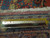 Reverse of the rug with ruler measuring knot count across ivory cotton foundation and fringe
