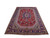 7'3" x 11'2" Persian Tabriz rug photographed at an angle showing red field and indigo border