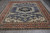 9x12 Indian Oriental rug shown on gray plank floor with rust and ivory geometric borders