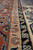 Border detail showing rust rosettes, tan vine guard stripe and navy blossom band