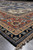 Low angle of the 8'11" x 12' rug showing ivory spandrels, rust border and fringe