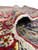 Large 8x12 Kashan rug folded back to reveal the tight hand-knotted back and ivory fringe