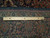 Reverse of the rug with ruler measuring knot density across the cotton foundation