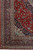 Corner detail of indigo main border, rose guard stripes and clean ivory fringe edge