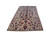 Angled view of ivory Persian wool rug showing scrolling vines, rose palmettes and narrow red edge