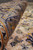 Rolled edge showing dense hand-knotted wool pile depth in taupe, cream and muted blue tones