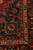 Corner detail showing ivory scrolling vine border, red guard stripe and dense hand-knotted wool pile