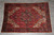 7' x 10' Persian Heriz rug laid flat on grey tile showing complete geometric field