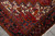 Corner detail where ivory spandrel meets black main border with orange and blue palmettes