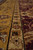 Border detail with cream guard stripe dividing the gold main border from the burgundy field