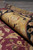Rolled edge of the wool rug showing gold border, black band and thick pile