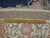 Back of the 6x9 oval Chinese rug with ruler showing even hand-knotted cotton foundation