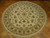 7' x 7' round Tabriz design rug displayed at an angle on herringbone parquet wood flooring
